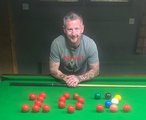 Clive O'Sullivan posing next to snooker balls arranged in the shape of a "102"