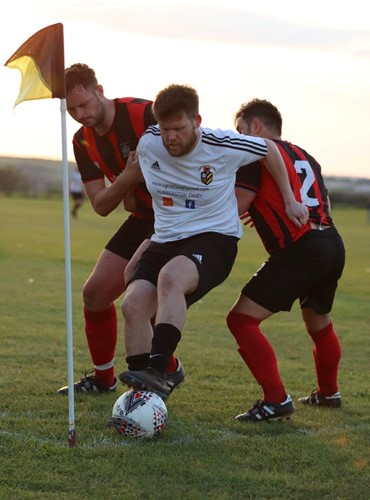 Scott Reid holds off two Tenby defenders